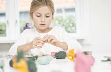 lille pige leger med ailefo økologisk modellervoks